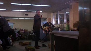Movie still from “Bullitt” (1968), directed by Peter Yates – A man standing in a room with a cell phone in his hand; Wide shot, Low angle