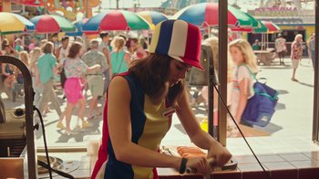 Movie still from “Bumblebee” (2018), directed by Travis Knight – A woman in a colorful outfit is cutting a cake; Medium shot, High angle