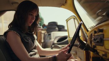 Movie still from “Bumblebee” (2018), directed by Travis Knight – A woman sitting in the driver's seat of a vehicle; Medium shot, Low angle