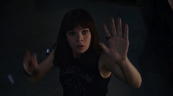 Movie still from “Bumblebee” (2018), directed by Travis Knight – A woman in a black shirt is holding her hand up; Close Up shot, High angle