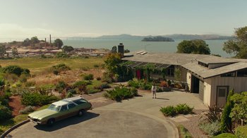 Movie still from “Bumblebee” (2018), directed by Travis Knight – A car parked in front of a house near a body of water; Extreme Wide shot, High angle