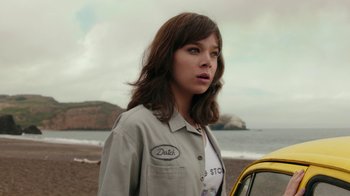 Movie still from “Bumblebee” (2018), directed by Travis Knight – A woman standing next to a car on the beach; Close Up shot, Low angle