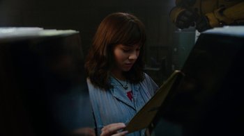 Movie still from “Bumblebee” (2018), directed by Travis Knight – A woman looking at a piece of paper in a dark room; Close Up shot, Over the shoulder angle