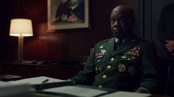 Movie still from “Bumblebee” (2018), directed by Travis Knight – A man in uniform sitting at a desk; Medium shot, Low angle