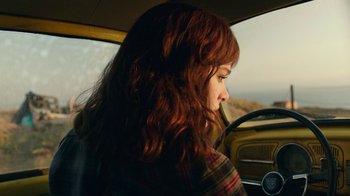 Movie still from “Bumblebee” (2018), directed by Travis Knight – A woman sitting in the driver's seat of a car; Medium shot, Low angle