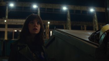 Movie still from “Bumblebee” (2018), directed by Travis Knight – A woman standing next to a building at night; Medium shot, Low angle
