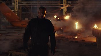 Movie still from “Bumblebee” (2018), directed by Travis Knight – A man standing in front of an explosion in a building; Medium shot, Low angle