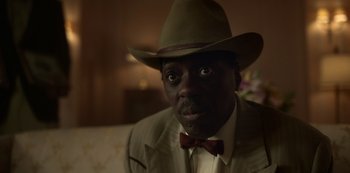 Movie still from “Fargo” (2014), created by Noah Hawley – A person wearing a hat and a bow tie; Close Up shot, Low angle