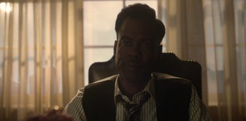 Movie still from “Fargo” (2014), created by Noah Hawley – A person sitting in a chair wearing a tie; Close Up shot, Over the shoulder angle