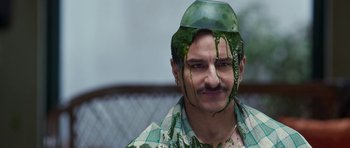 Movie still from “Bunty Aur Babli 2” (2021), directed by Varun V. Sharma – A man with green hair and a green hat on his head; Close Up shot, High angle