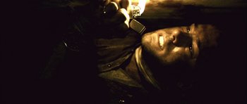 Movie still from “Buried” (2010), directed by Rodrigo Cortés – A man laying on the ground holding a cell phone up to his ear; Close Up shot, Overhead angle