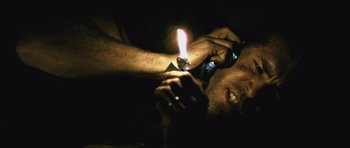 Movie still from “Buried” (2010), directed by Rodrigo Cortés – A man is holding a lit candle in his hand; Close Up shot, Overhead angle