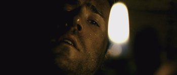 Movie still from “Buried” (2010), directed by Rodrigo Cortés – A man's face with a light shining on his face; Extreme Close Up shot, Low angle