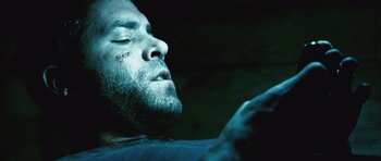 Movie still from “Buried” (2010), directed by Rodrigo Cortés – A person laying on his stomach; Close Up shot, Overhead angle