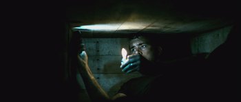 Movie still from “Buried” (2010), directed by Rodrigo Cortés – A man is holding a candle in his hand; Medium shot, Low angle
