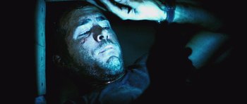 Movie still from “Buried” (2010), directed by Rodrigo Cortés – A person laying on the ground at night; Close Up shot, Overhead angle