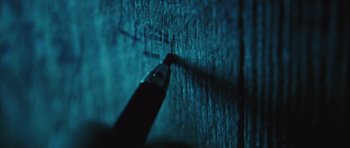 Movie still from “Buried” (2010), directed by Rodrigo Cortés – A pencil with a blue light shining on it; Extreme Close Up shot, Overhead angle
