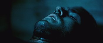 Movie still from “Buried” (2010), directed by Rodrigo Cortés – A man's face in the dark; Extreme Close Up shot, Low angle