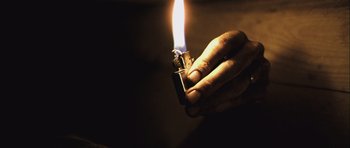 Movie still from “Buried” (2010), directed by Rodrigo Cortés – A person holding a lighter in their hand; Extreme Close Up shot, High angle