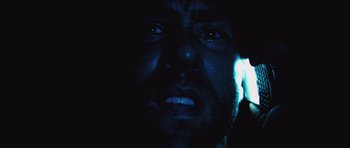 Movie still from “Buried” (2010), directed by Rodrigo Cortés – A man's face in the dark; Extreme Close Up shot, Low angle