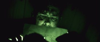 Movie still from “Buried” (2010), directed by Rodrigo Cortés – A man looking at a cell phone in a dark room; Extreme Close Up shot, Low angle