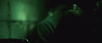 Movie still from “Buried” (2010), directed by Rodrigo Cortés – A person with a green light in the background; Extreme Close Up shot, Over the shoulder angle