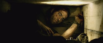 Movie still from “Buried” (2010), directed by Rodrigo Cortés – A person laying on the ground; Medium shot, Overhead angle