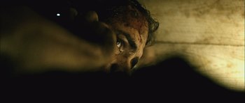 Movie still from “Buried” (2010), directed by Rodrigo Cortés – A man with a bloody face laying on a bed; Extreme Close Up shot, Overhead angle