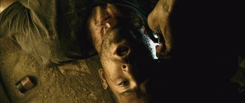 Movie still from “Buried” (2010), directed by Rodrigo Cortés – A man laying on the ground looking at a cell phone; Extreme Close Up shot, Overhead angle