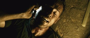 Movie still from “Buried” (2010), directed by Rodrigo Cortés – A man laying on the ground with blood all over his face; Close Up shot, Overhead angle