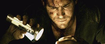 Movie still from “Buried” (2010), directed by Rodrigo Cortés – A person holding a flashlight; Close Up shot, Low angle