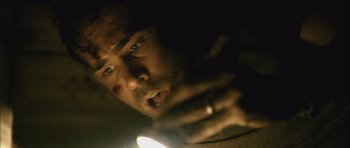 Movie still from “Buried” (2010), directed by Rodrigo Cortés – A person with a light in their hand; Extreme Close Up shot, Low angle