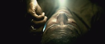 Movie still from “Buried” (2010), directed by Rodrigo Cortés – A man with his eyes closed and a hand touching his face; Extreme Close Up shot, Overhead angle