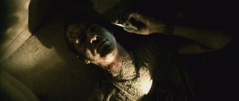 Movie still from “Buried” (2010), directed by Rodrigo Cortés – A man with dirt all over his face is holding a cell phone; Close Up shot, Overhead angle