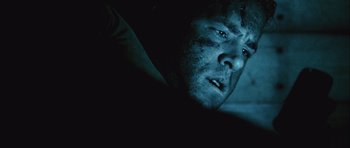 Movie still from “Buried” (2010), directed by Rodrigo Cortés – A man's face in the dark; Close Up shot, Low angle