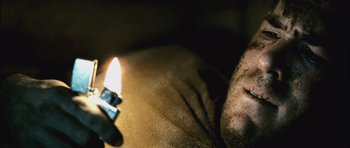 Movie still from “Buried” (2010), directed by Rodrigo Cortés – A man laying in bed with a lit candle in his hand; Extreme Close Up shot, High angle