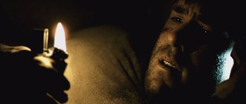 Movie still from “Buried” (2010), directed by Rodrigo Cortés – A man's face and chest in a dark room; Extreme Close Up shot, High angle