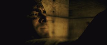 Movie still from “Buried” (2010), directed by Rodrigo Cortés – A man is looking at the camera with a blurry background; Extreme Close Up shot, Low angle