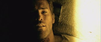 Movie still from “Buried” (2010), directed by Rodrigo Cortés – A man's face in the dark; Close Up shot, Overhead angle