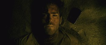 Movie still from “Buried” (2010), directed by Rodrigo Cortés – A person in the dirt; Close Up shot, Overhead angle