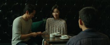 A woman sitting at a table with two cups of coffee