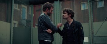 Movie still from “Burnt” (2015), directed by John Wells – A couple of men standing next to each other; Medium shot, Low angle