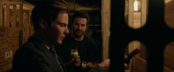 Movie still from “Burnt” (2015), directed by John Wells – Two men standing in front of each other holding drinks; Medium shot, Over the shoulder angle