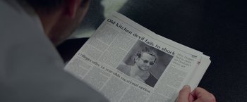 Movie still from “Burnt” (2015), directed by John Wells – An old newspaper with a picture of a man wearing sunglasses; Extreme Close Up shot, High angle