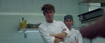 Movie still from “Burnt” (2015), directed by John Wells – A couple of men standing next to each other in a kitchen; Medium shot, Low angle