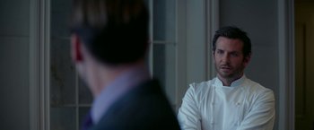 Movie still from “Burnt” (2015), directed by John Wells – A man wearing a white shirt and a tie; Close Up shot, Over the shoulder angle