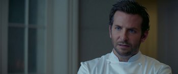 Movie still from “Burnt” (2015), directed by John Wells – A person wearing a chef's outfit; Close Up shot, Over the shoulder angle