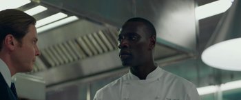 Movie still from “Burnt” (2015), directed by John Wells – A man in a chef's outfit in a restaurant kitchen; Close Up shot, Low angle