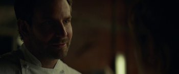 Movie still from “Burnt” (2015), directed by John Wells – A man's face in a dark room; Close Up shot, Over the shoulder angle