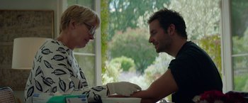 Movie still from “Burnt” (2015), directed by John Wells – A man and a woman sitting in front of a window; Medium shot, Low angle